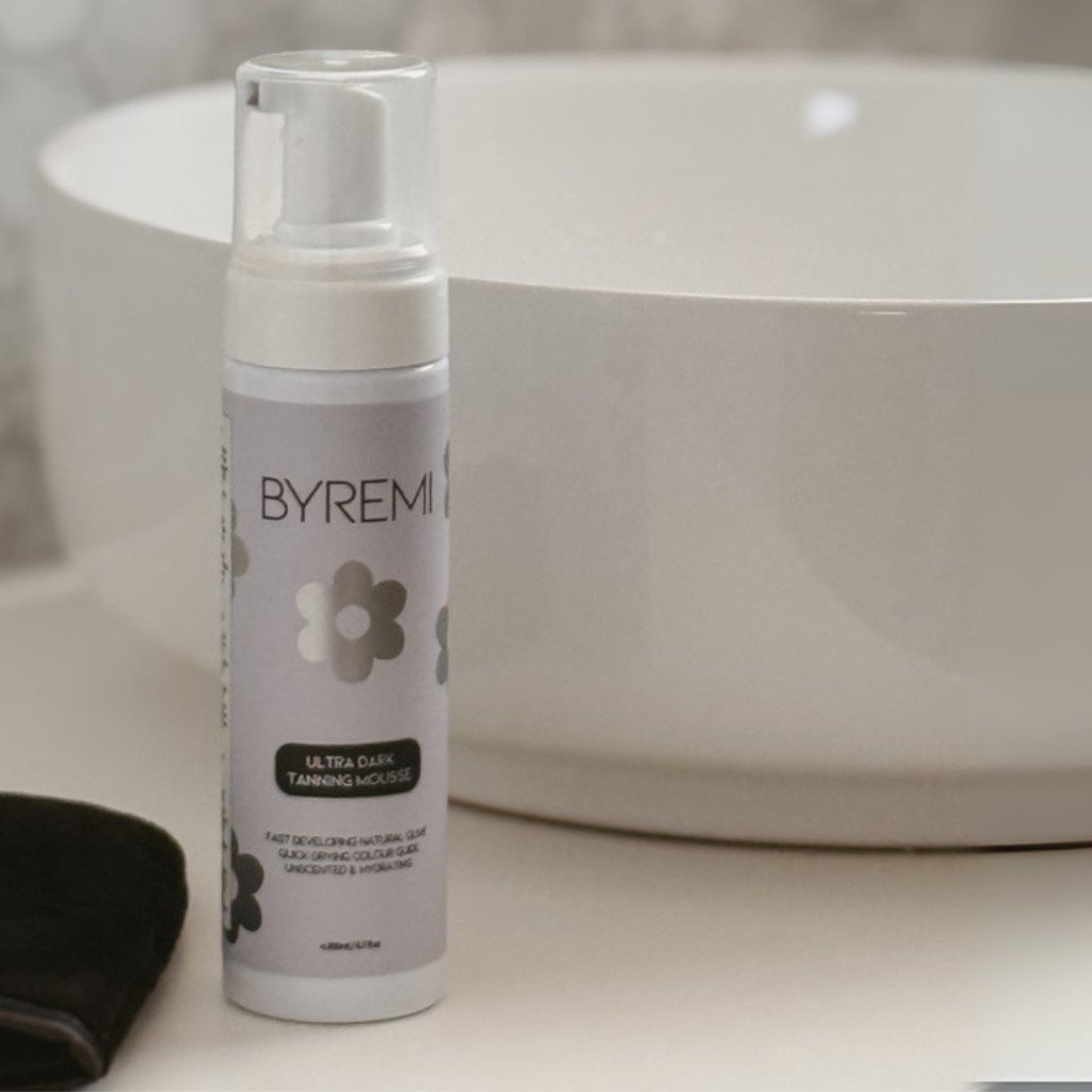 Byremi tanning moisturizer bottle on a bathroom counter with a blurred background