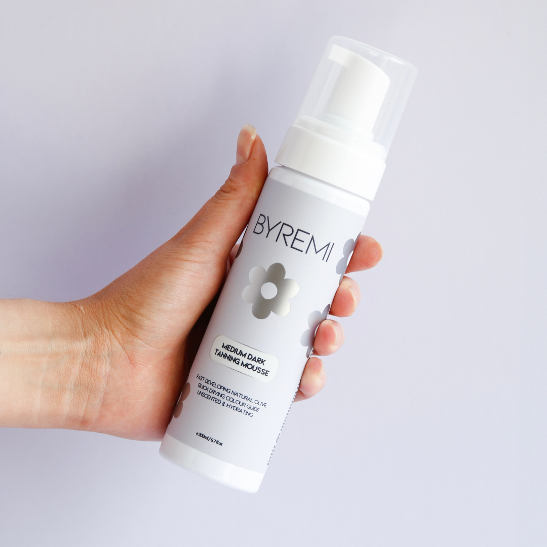 model holding bottle of byremi nz best self tan in medium dark