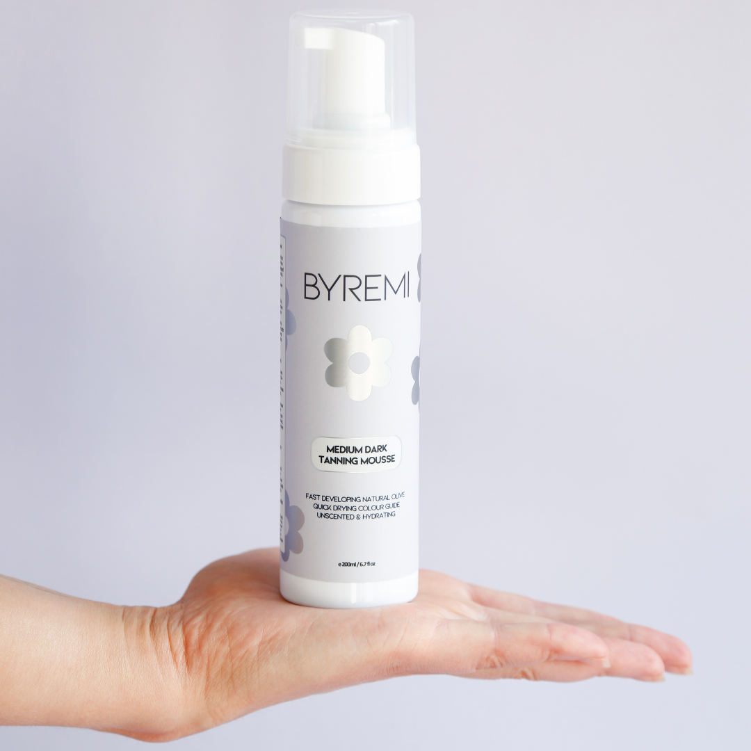 model holding bottle of byremi nz best self tan in the medium dark